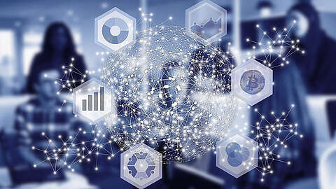 Eine digitale Illustration eines Globus, bestehend aus miteinander verbundenen Knoten und Linien. Um den Globus herum befinden sich Sechsecke mit Symbolen, die verschiedene Technologien darstellen, wie beispielsweise Diagramme und ein Bitcoin-Symbol. Menschen sind im Hintergrund unscharf dargestellt.