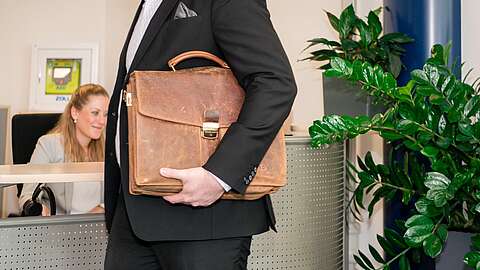 eine Person mit Aktentasche unter dem Arm